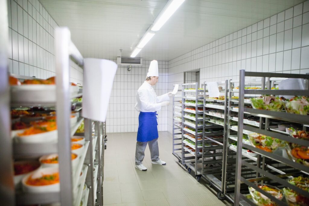 Chef checking racks of plated meals